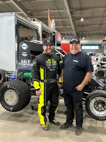 Joey Klemish in his custom yellow and black suit beside his car